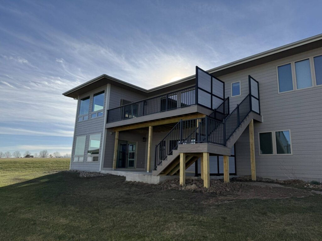 Finished two story home addition with rear deck and matched exterior finishes in Central Iowa