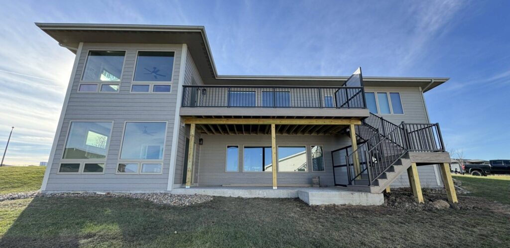 Finished two story home addition with upper deck and metal railings on an Iowa property