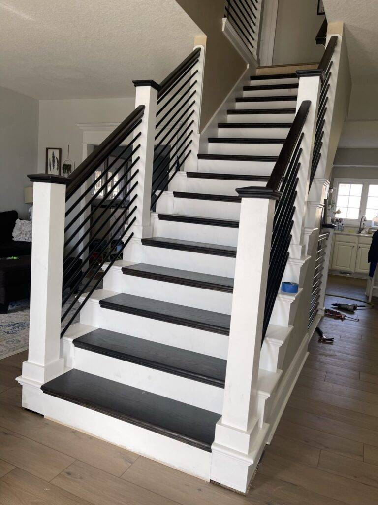 Interior remodel staircase with dark treads, white risers, and horizontal metal railings