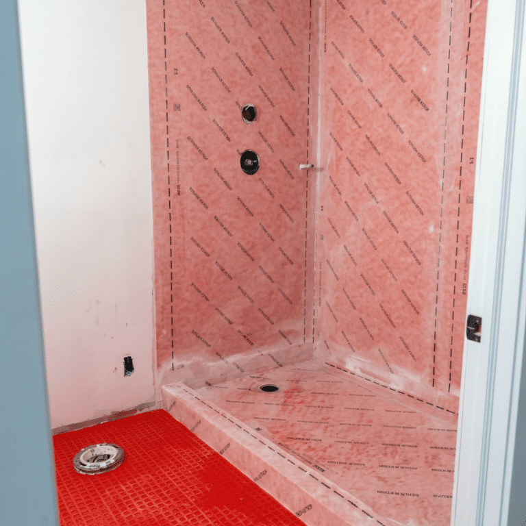 Bathroom remodeling shower waterproofing with Schluter Kerdi membrane on walls and shower pan, plumbing valve rough-in, and Ditra membrane on bathroom floor