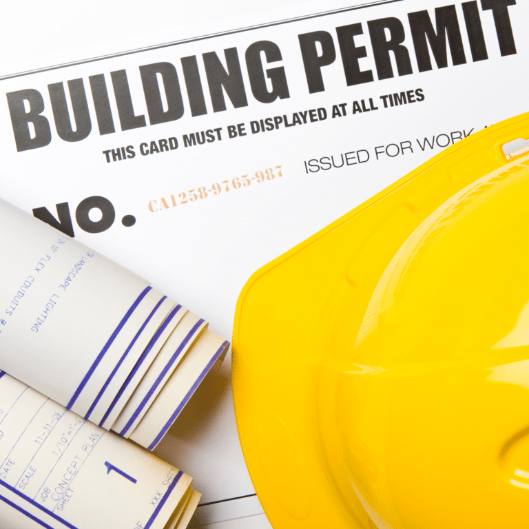 Building permit card with yellow hard hat and rolled construction blueprints for a home addition project
