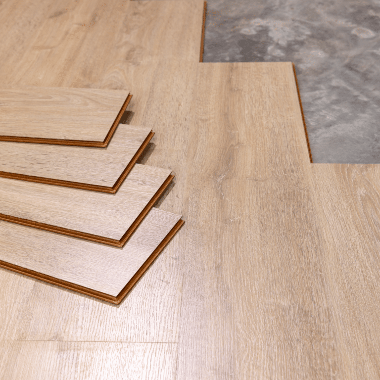 engineered hardwood flooring planks being installed over concrete subfloor during new home construction