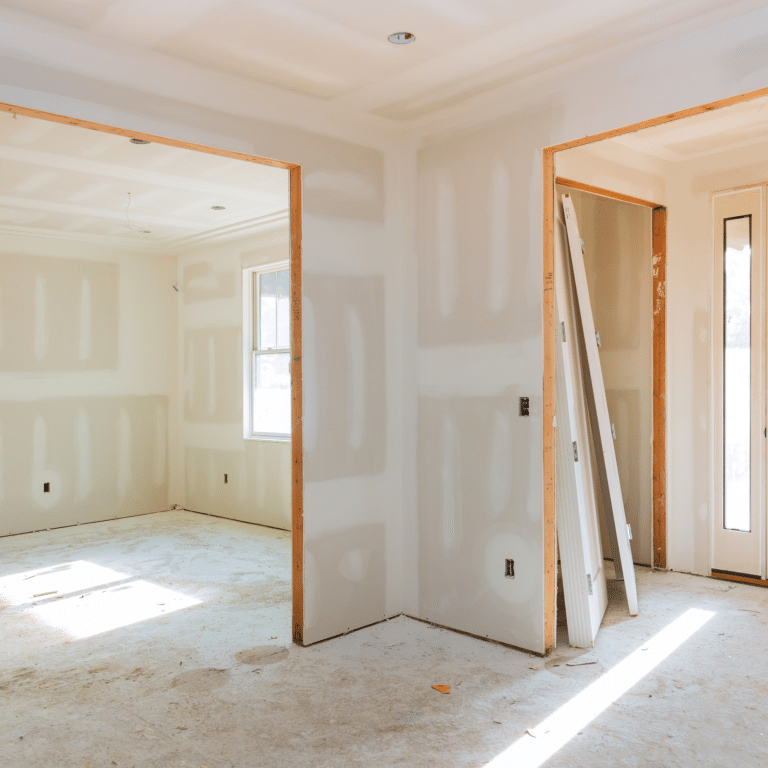 New home construction drywall installation with taped and mudded walls, door rough openings, and interior doors staged for hanging